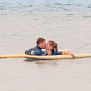Zeit als Paar verbringen während Kind am Strand betreut wird