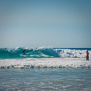 Während du surfst, bekommst du Live-Tipps über Funk – so klappt auch der Backside Cutback.