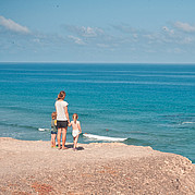 Familie mit kleinen Kindern am Surfstrand